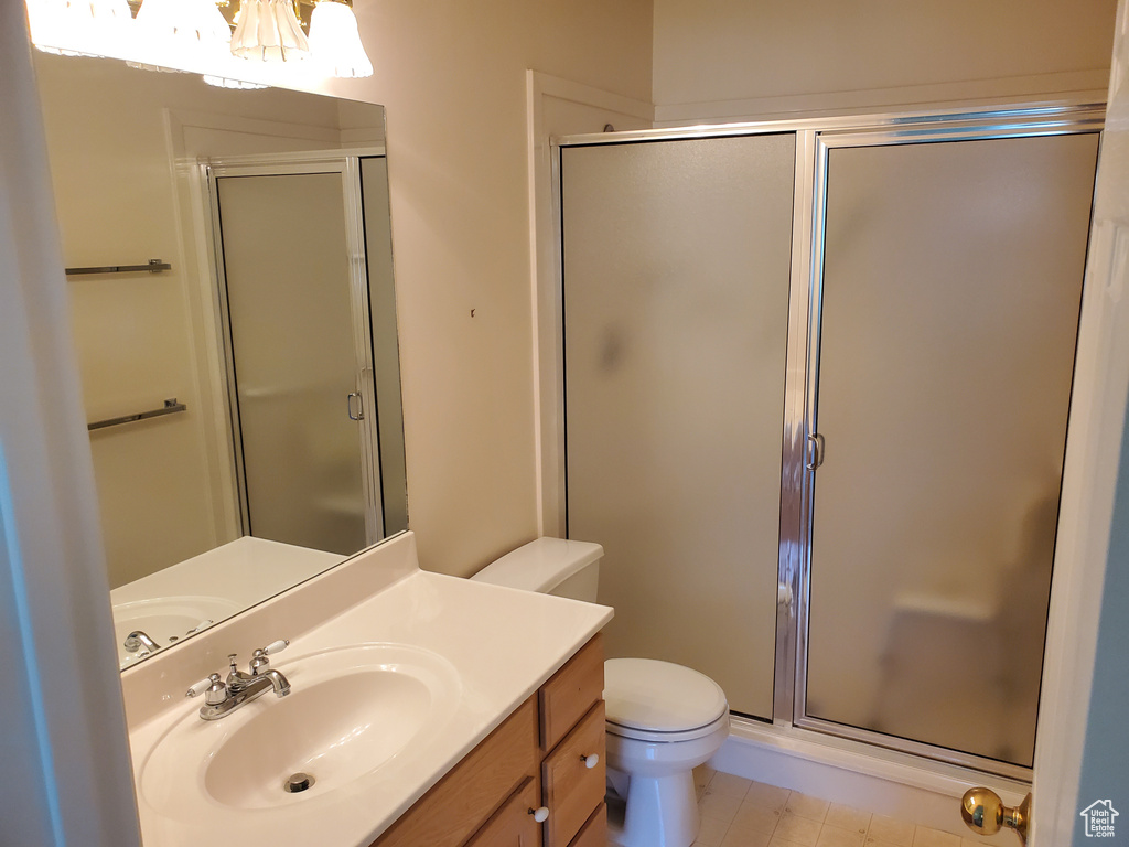 Full bathroom featuring a chandelier, a stall shower, toilet, and vanity