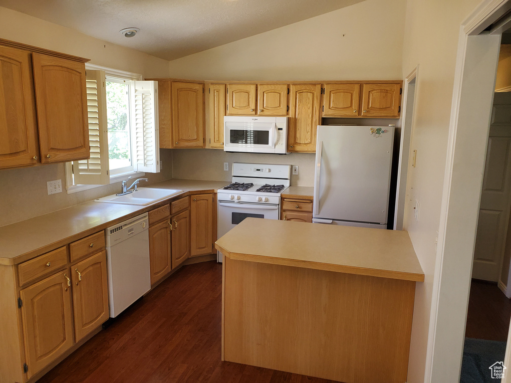 Kitchen with white appliances, a sink, dark wood-style floors, light countertops, and lofted ceiling