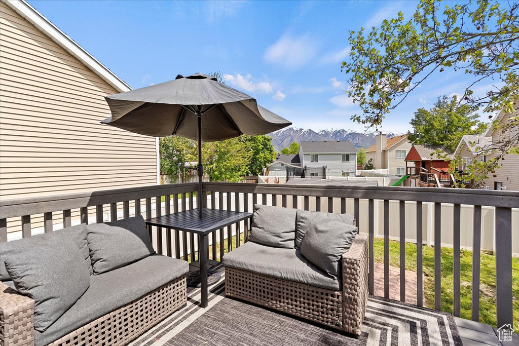 Wooden terrace with a residential view, a mountain view, and fence