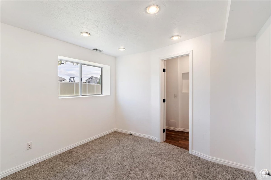 Carpeted spare room featuring baseboards and recessed lighting