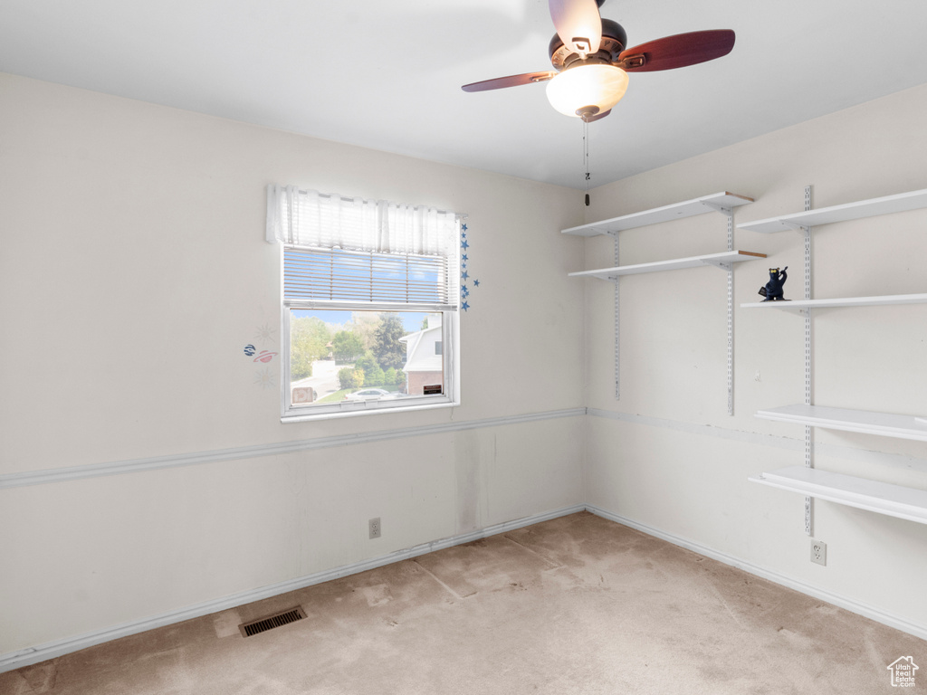Unfurnished room with light colored carpet, ceiling fan, and baseboards
