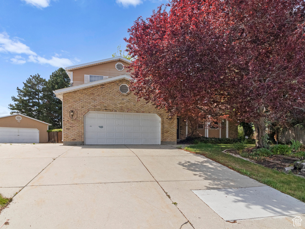 View of front of home featuring brick siding and concrete driveway