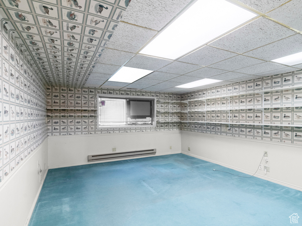 Unfurnished room featuring a baseboard heating unit, baseboards, and carpet floors