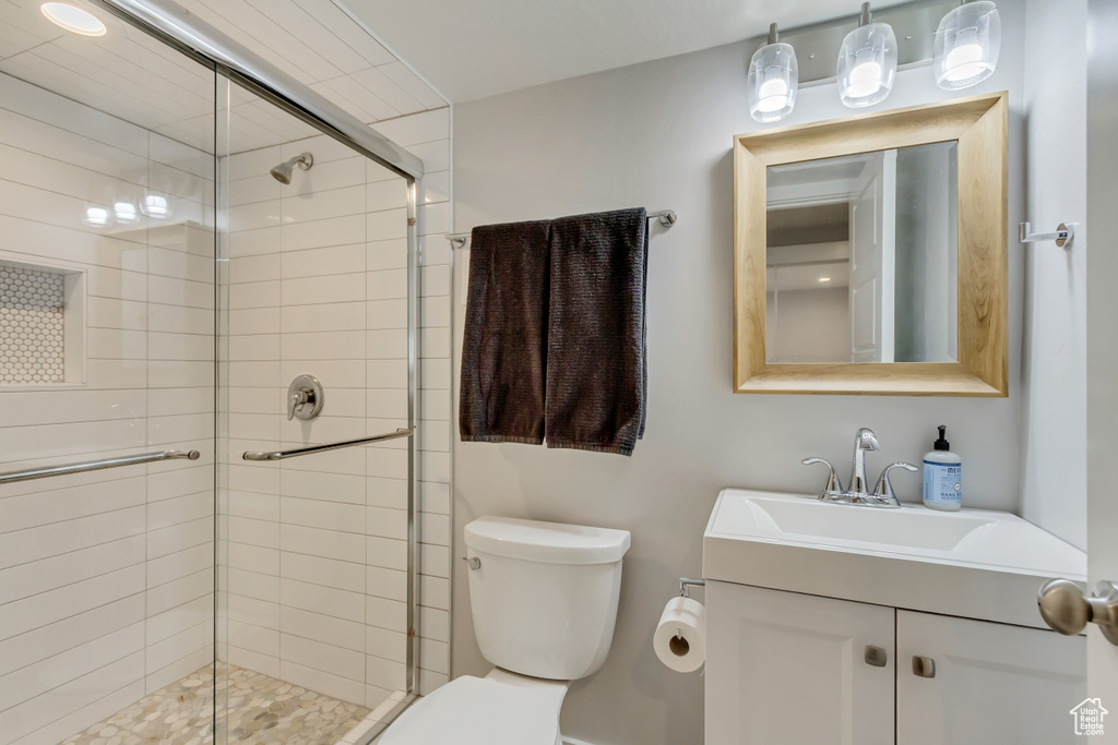 Full bath featuring vanity, toilet, and a stall shower