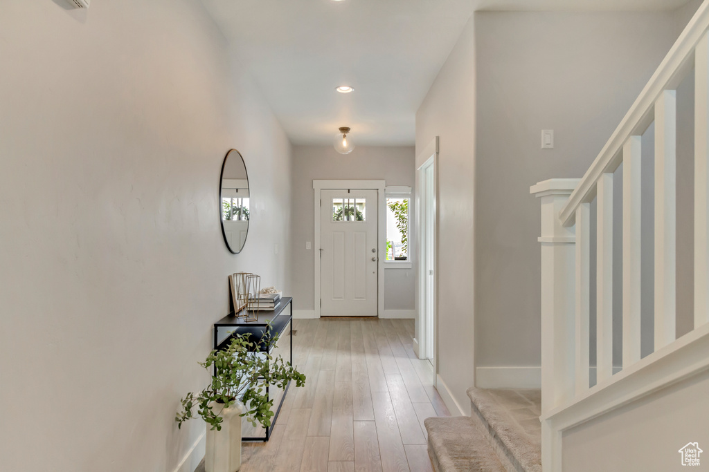 Entryway featuring baseboards, stairway, light wood-style flooring, and recessed lighting