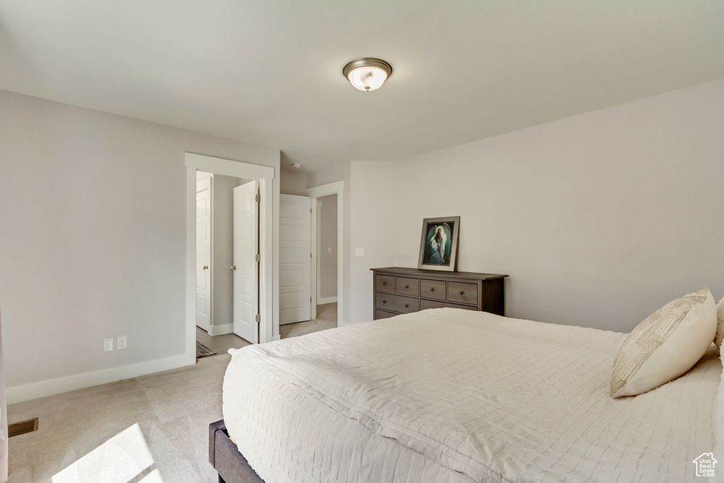 Bedroom with light colored carpet and baseboards