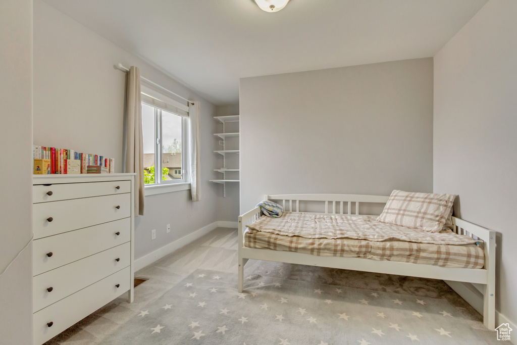 Bedroom featuring light carpet and baseboards