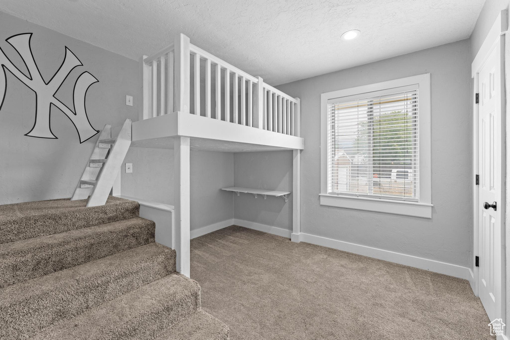Staircase with carpet floors, a textured ceiling, baseboards, and recessed lighting
