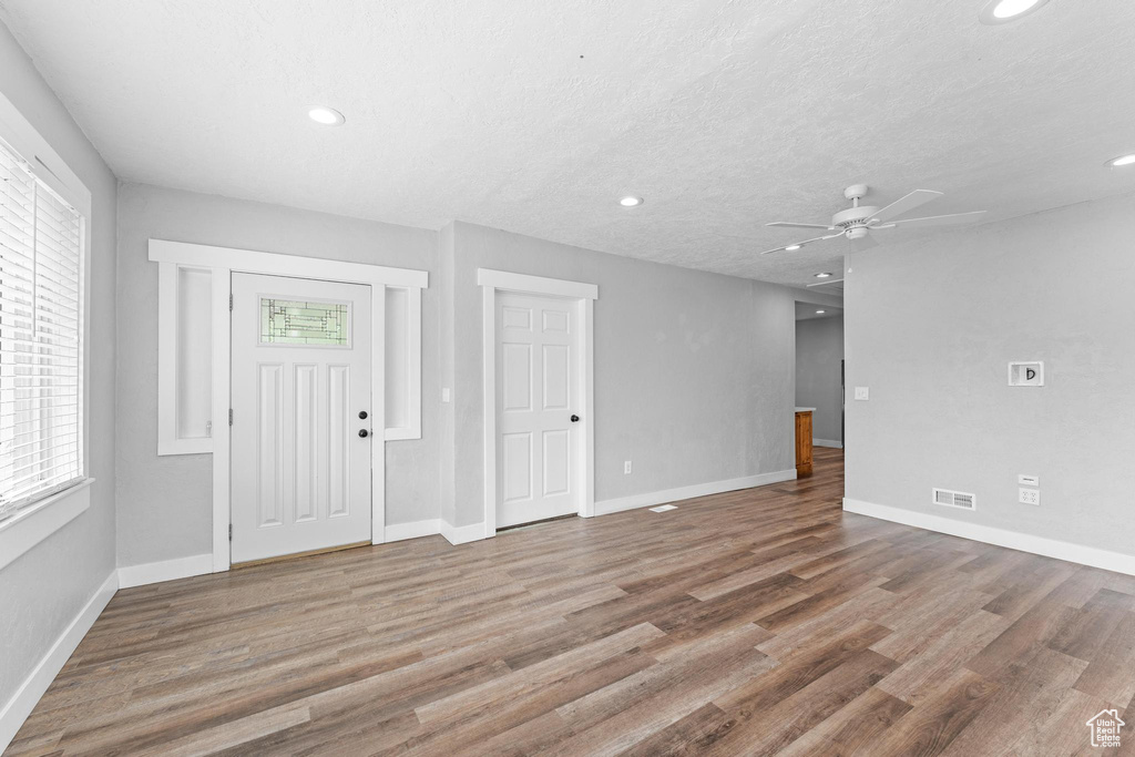 Foyer with ceiling fan, wood finished floors, healthy amount of natural light, baseboards, and recessed lighting