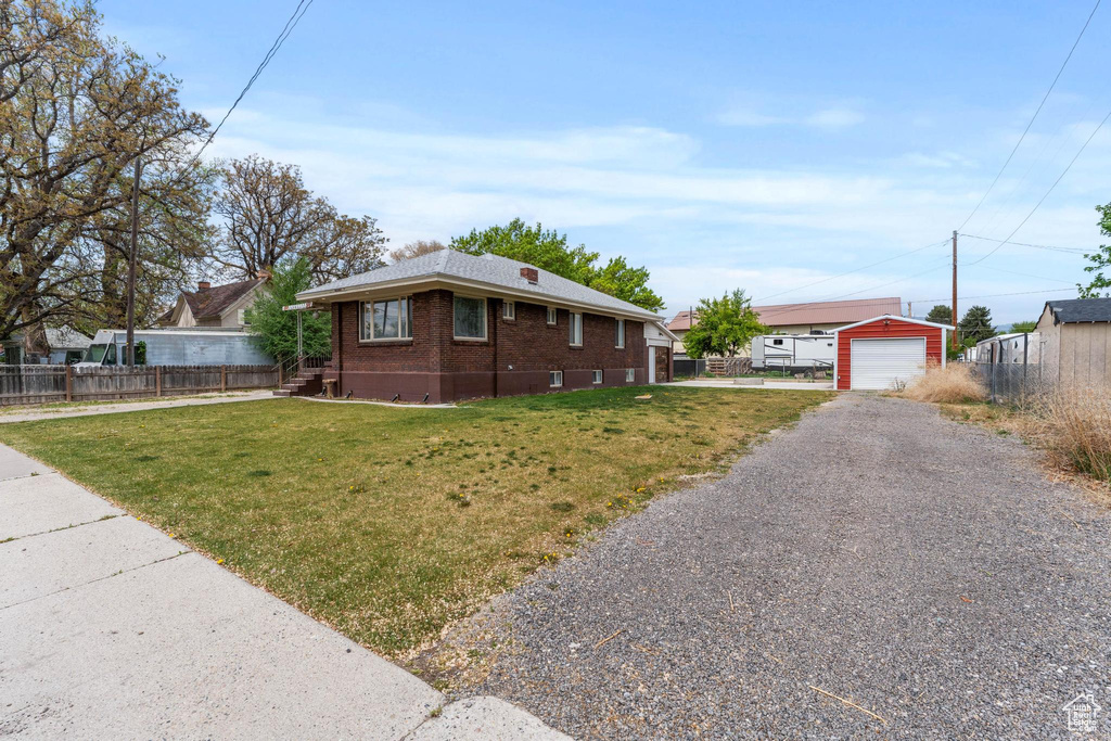 Ranch-style home featuring brick siding, driveway, and a detached garage