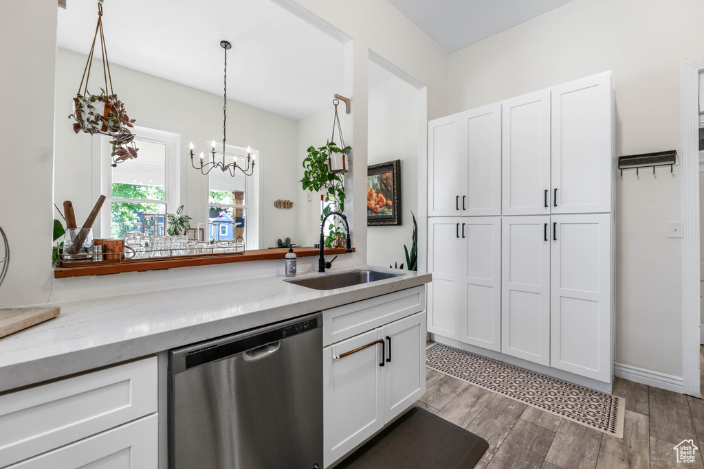 Kitchen featuring white cabinetry, an inviting chandelier, a sink, and dishwasher