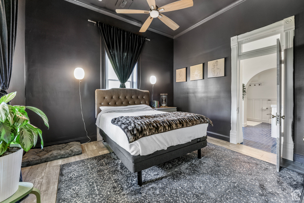 Bedroom with ornamental molding, ceiling fan, visible vents, wood finished floors, and arched walkways