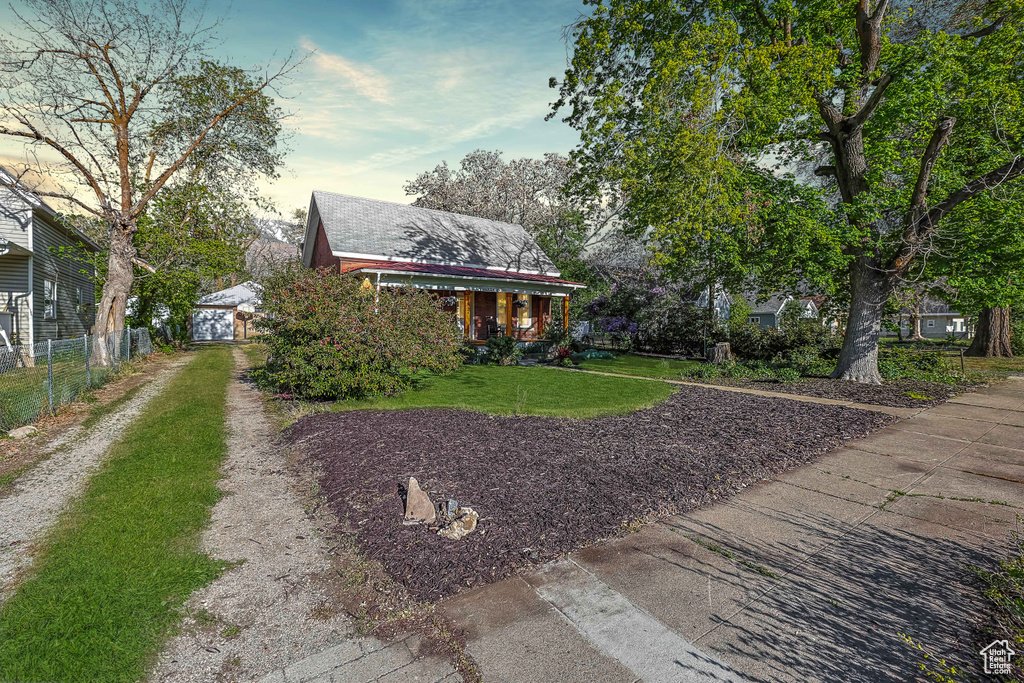 View of front of house featuring fence and a front lawn