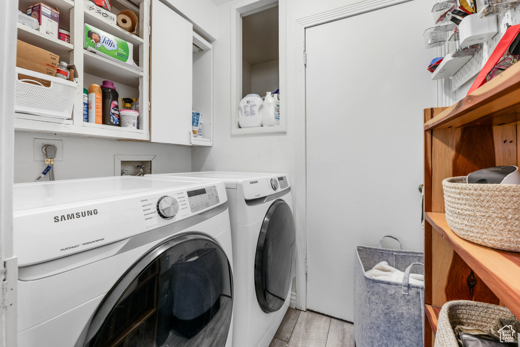 Laundry room featuring washer and clothes dryer, laundry area, and light wood-style floors