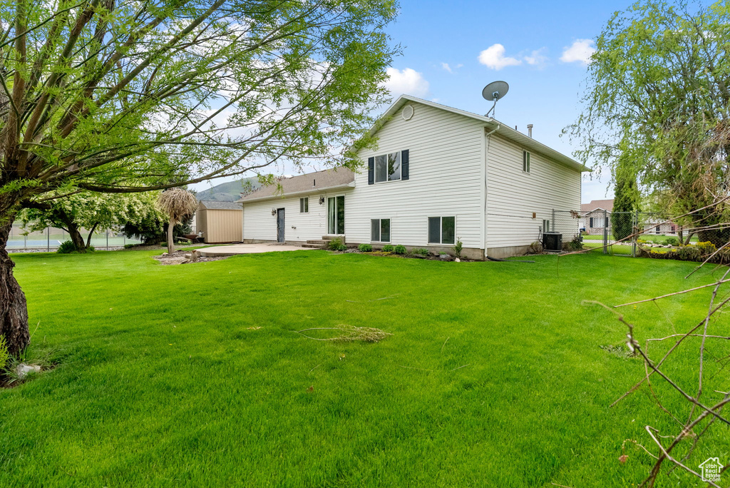 Back of house with a patio area, a shed, an outdoor structure, and central air condition unit
