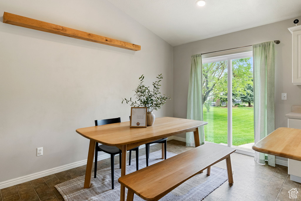 Dining room with lofted ceiling, baseboards, and recessed lighting