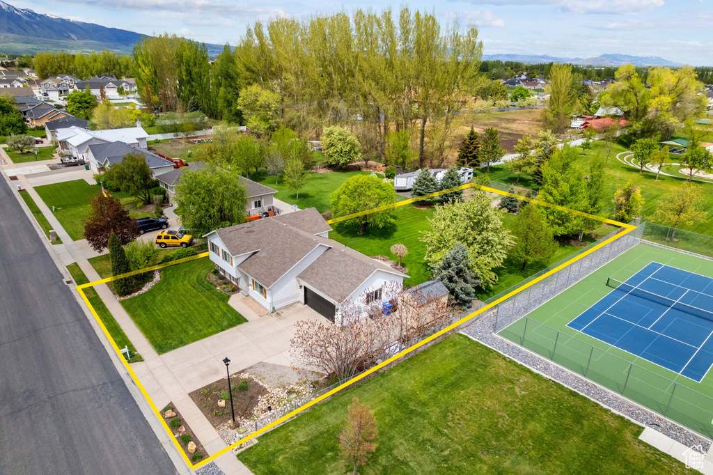 Aerial perspective of suburban area with property boundaries highlighted and a mountain backdrop
