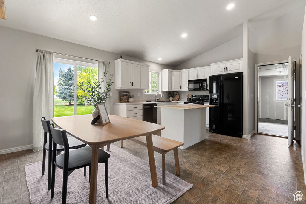 Kitchen with black appliances, a center island, white cabinetry, plenty of natural light, and recessed lighting