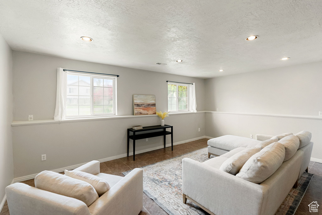 Living room featuring baseboards, recessed lighting, and a textured ceiling