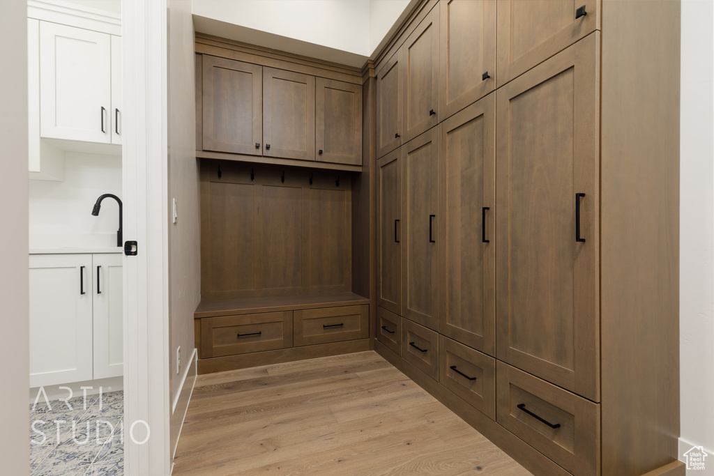Mudroom featuring light wood-style flooring and a sink