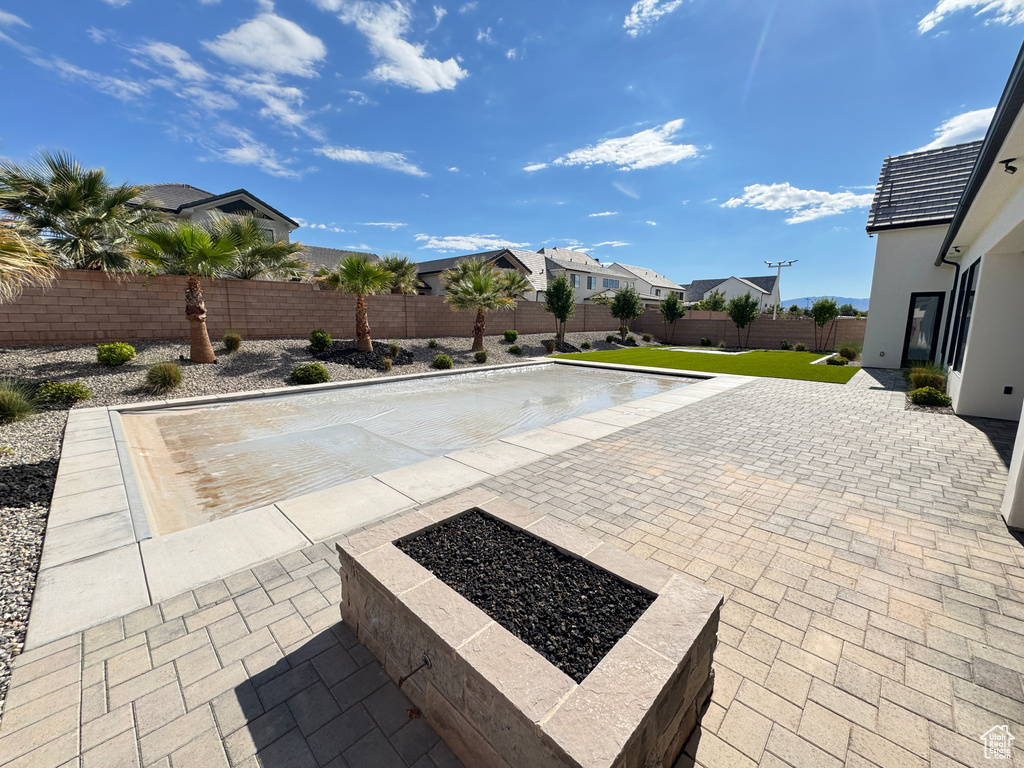 View of pool featuring a patio, a fenced backyard, and a residential view