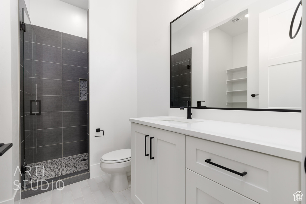 Full bathroom with a stall shower, toilet, and vanity