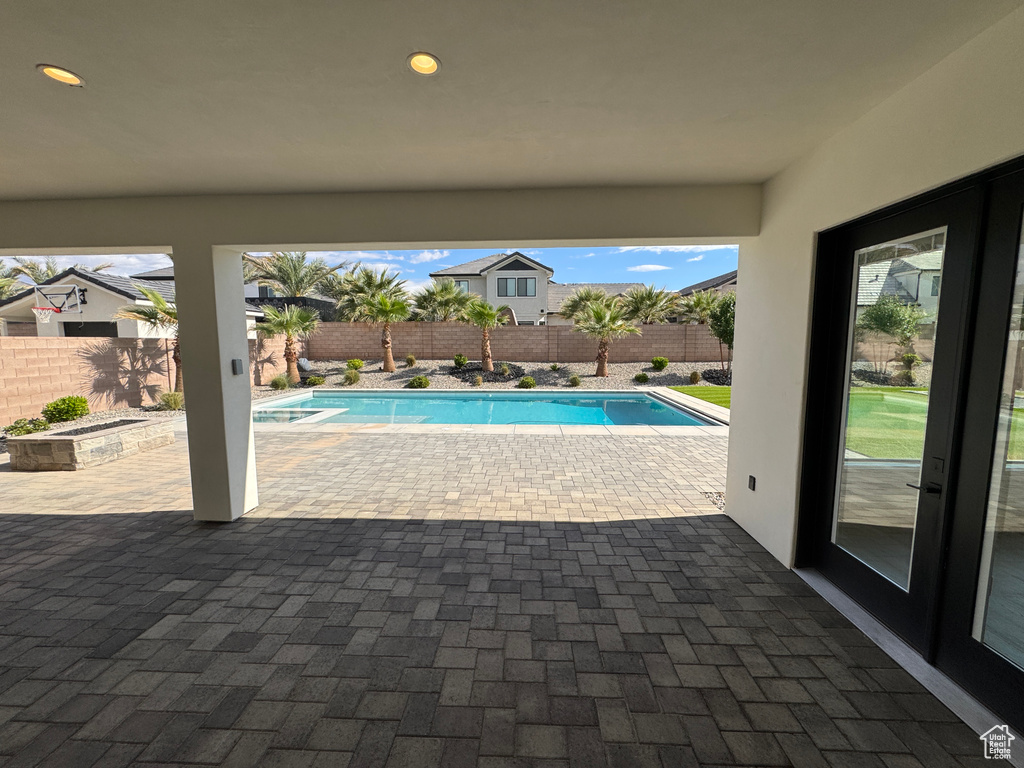 View of pool with a patio, a fenced backyard, and an in-ground hot tub