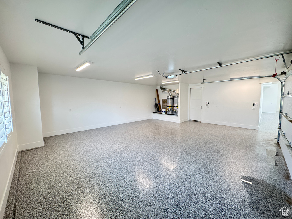 Garage featuring baseboards and a garage door opener