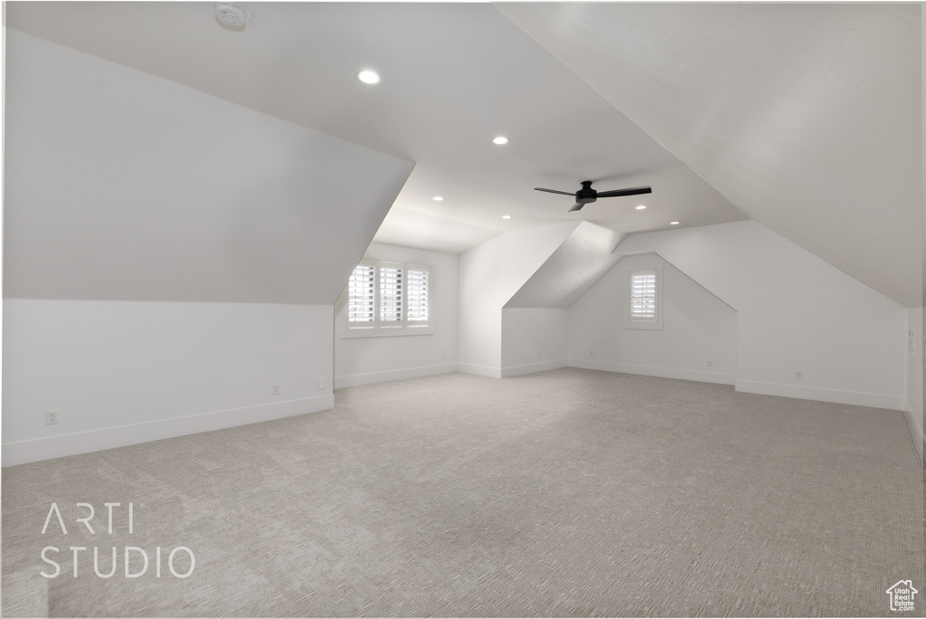 Additional living space with vaulted ceiling, recessed lighting, plenty of natural light, light carpet, and baseboards