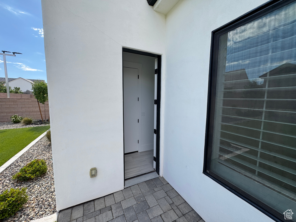 Doorway to property with stucco siding and fence