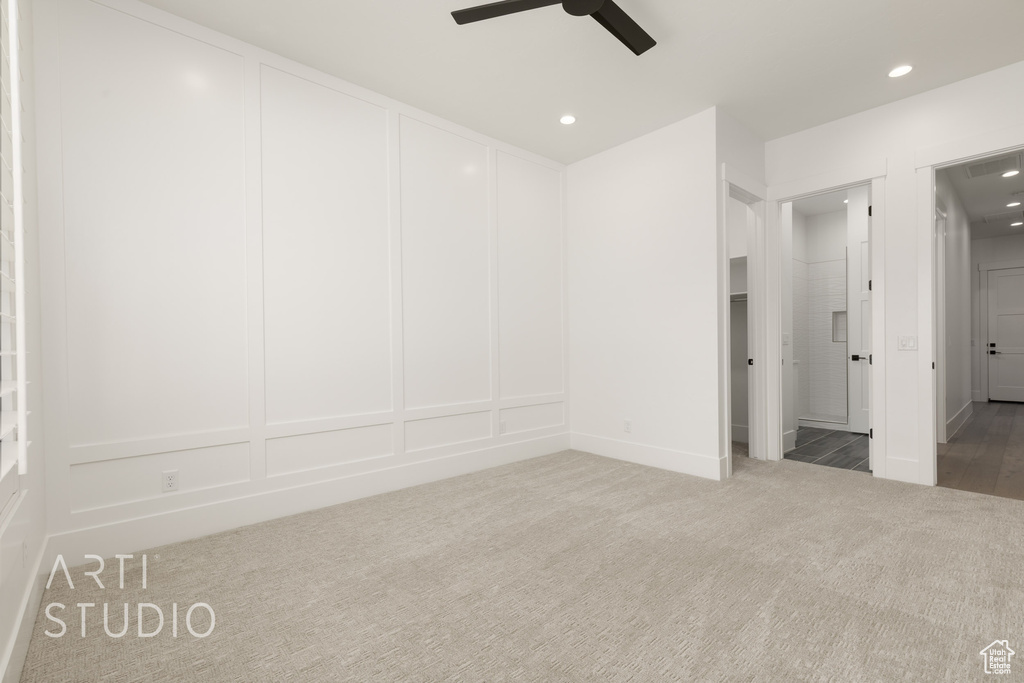 Unfurnished bedroom with a decorative wall, carpet, recessed lighting, and ceiling fan