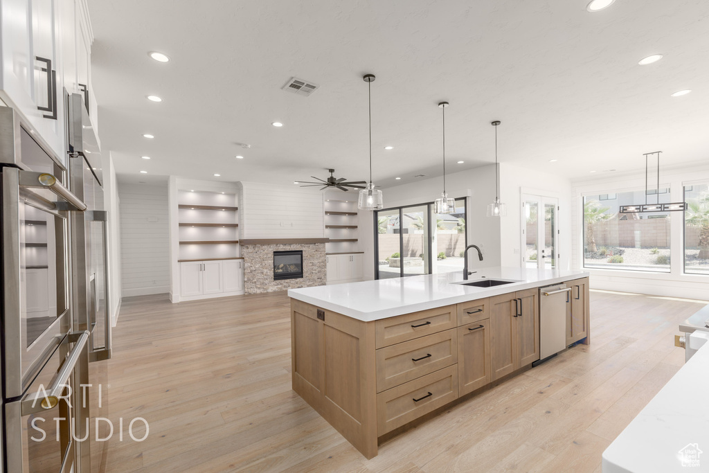 Kitchen with open floor plan, light brown cabinetry, a sink, recessed lighting, and ceiling fan