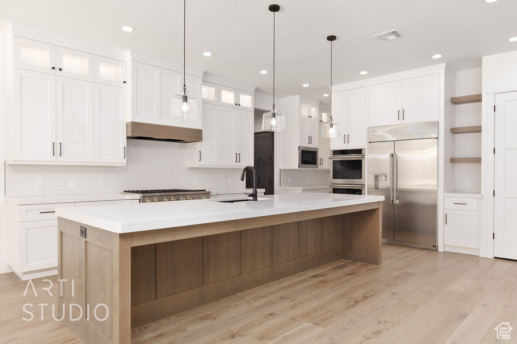 Kitchen with appliances with stainless steel finishes, a sink, decorative backsplash, white cabinetry, and recessed lighting