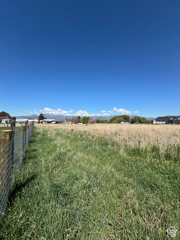 View of yard with fence and a view of rural / pastoral area
