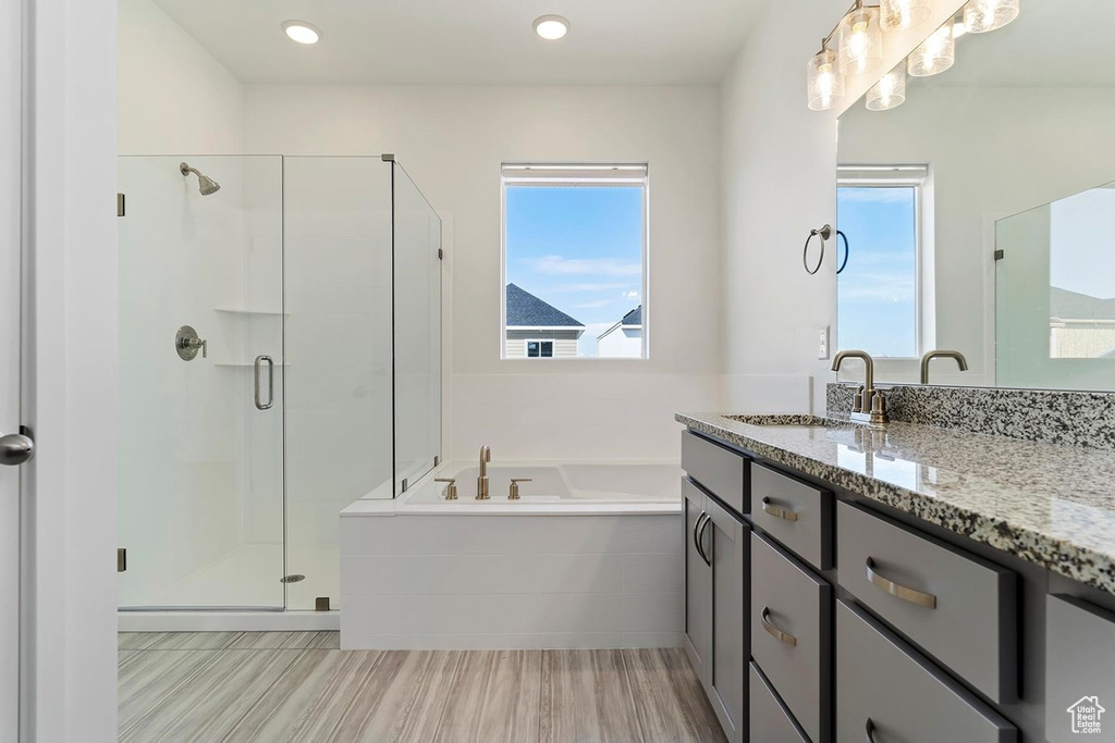 Full bath featuring a shower stall, a garden tub, and vanity