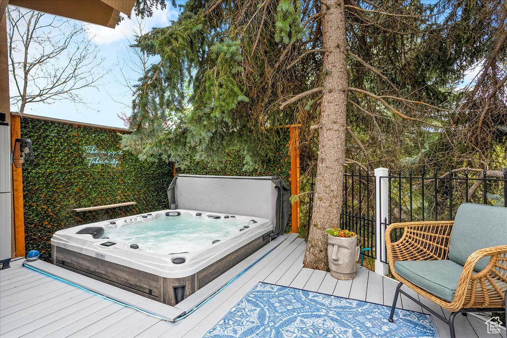 Wooden terrace featuring a covered hot tub