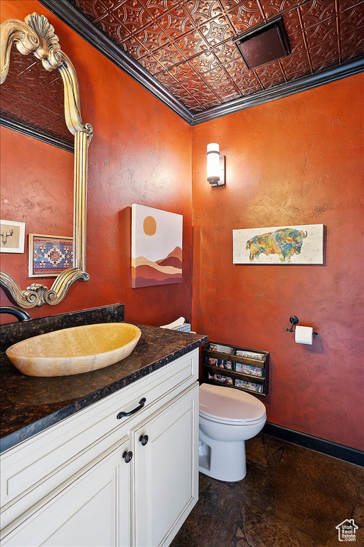 Bathroom featuring toilet, vanity, an ornate ceiling, and baseboards