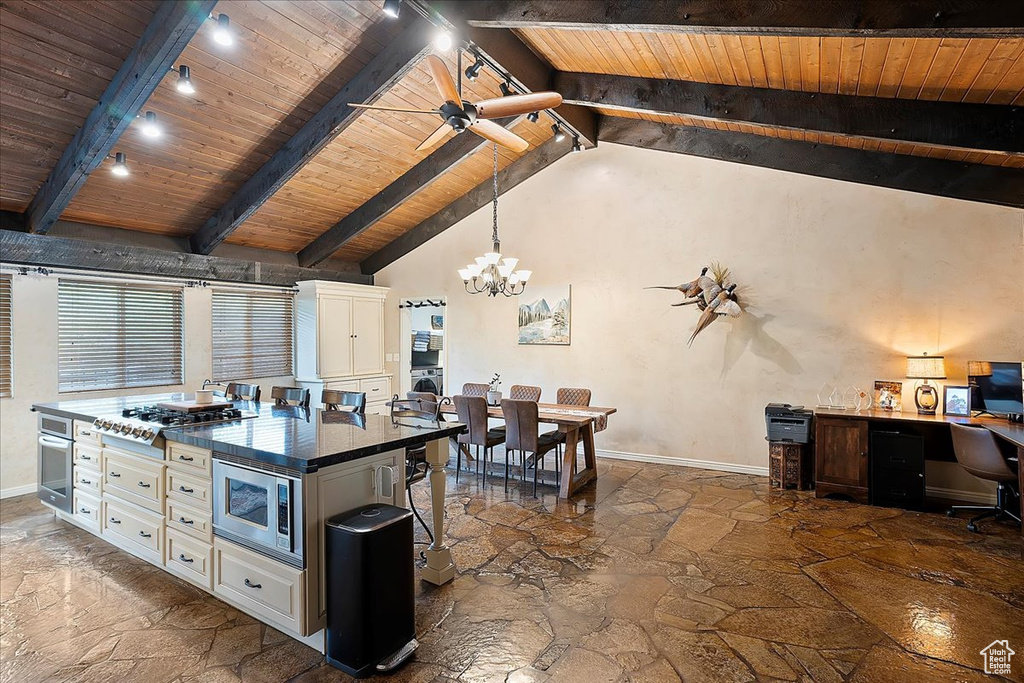 Kitchen featuring stone flooring, appliances with stainless steel finishes, wooden ceiling, a chandelier, and baseboards