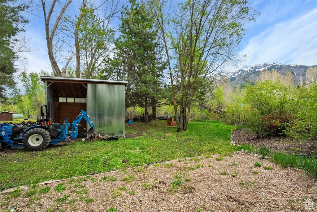 View of grassy yard with an outbuilding and a mountain view