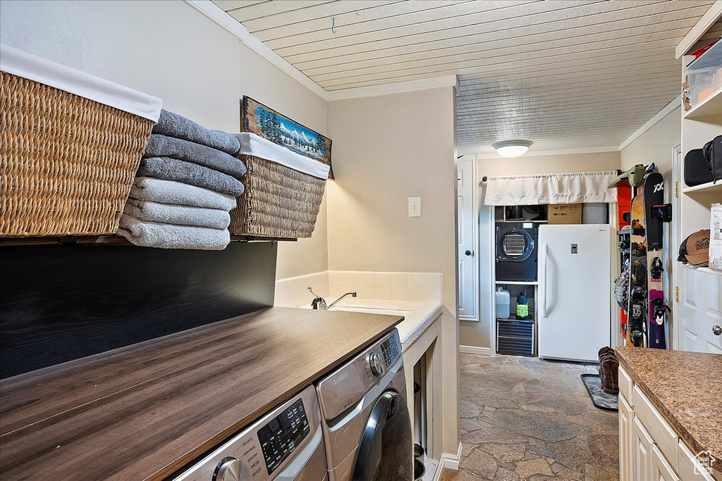 Laundry area with washer and clothes dryer, stone tile floors, crown molding, and wood ceiling