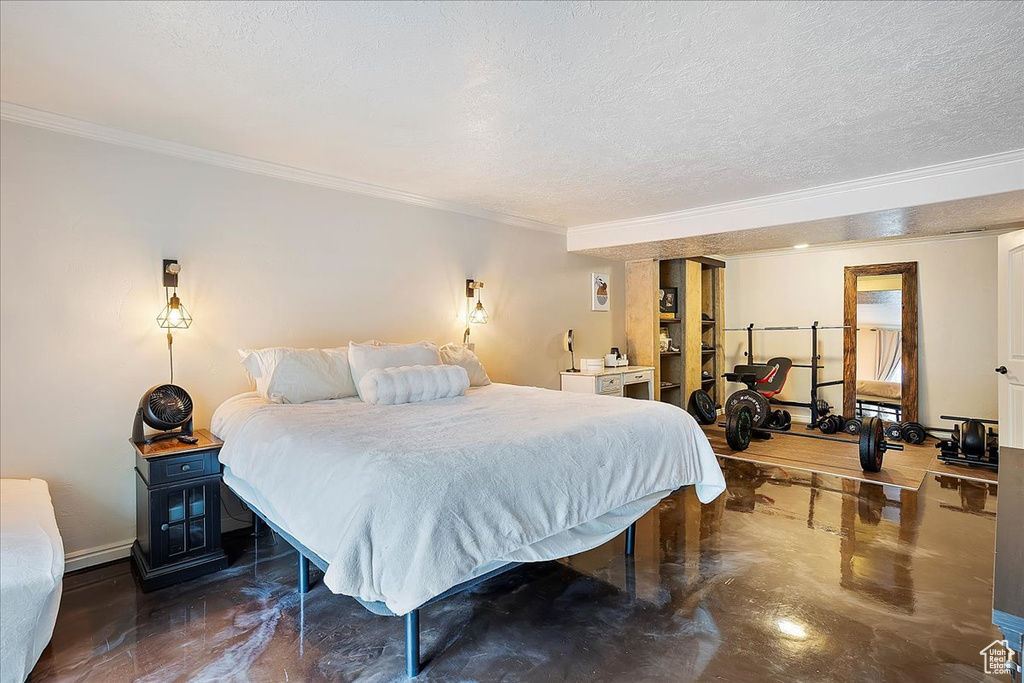 Bedroom featuring ornamental molding, concrete flooring, baseboards, and a textured ceiling