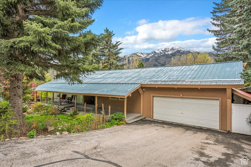 View of front of house featuring a garage, a mountain view, stucco siding, and asphalt driveway