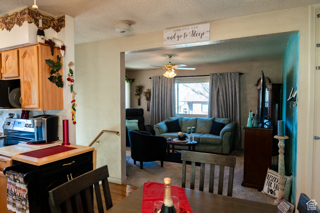 Dining area featuring a textured ceiling, a ceiling fan, wood finished floors, and baseboards