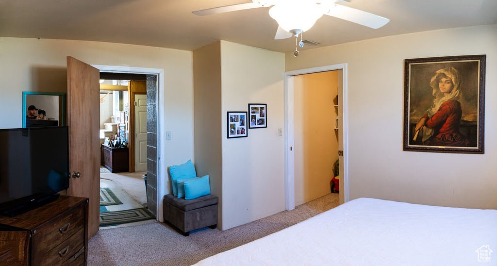 Carpeted bedroom featuring ceiling fan