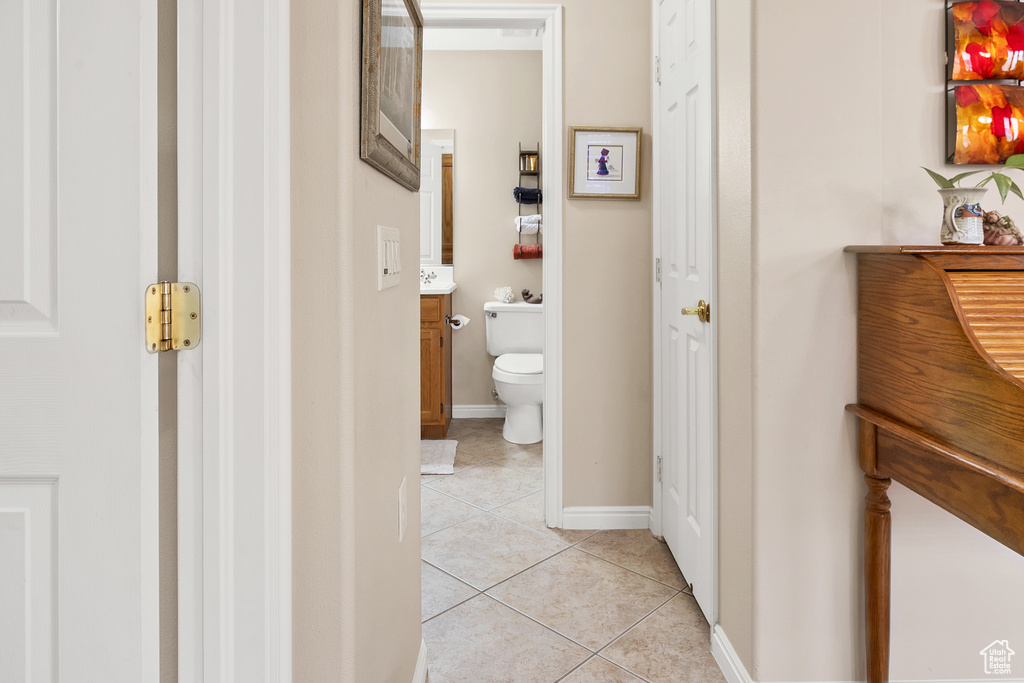 Bathroom featuring tile patterned flooring, vanity, toilet, and baseboards