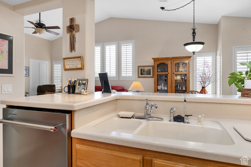 Kitchen with dishwasher, a sink, ceiling fan, lofted ceiling, and light countertops