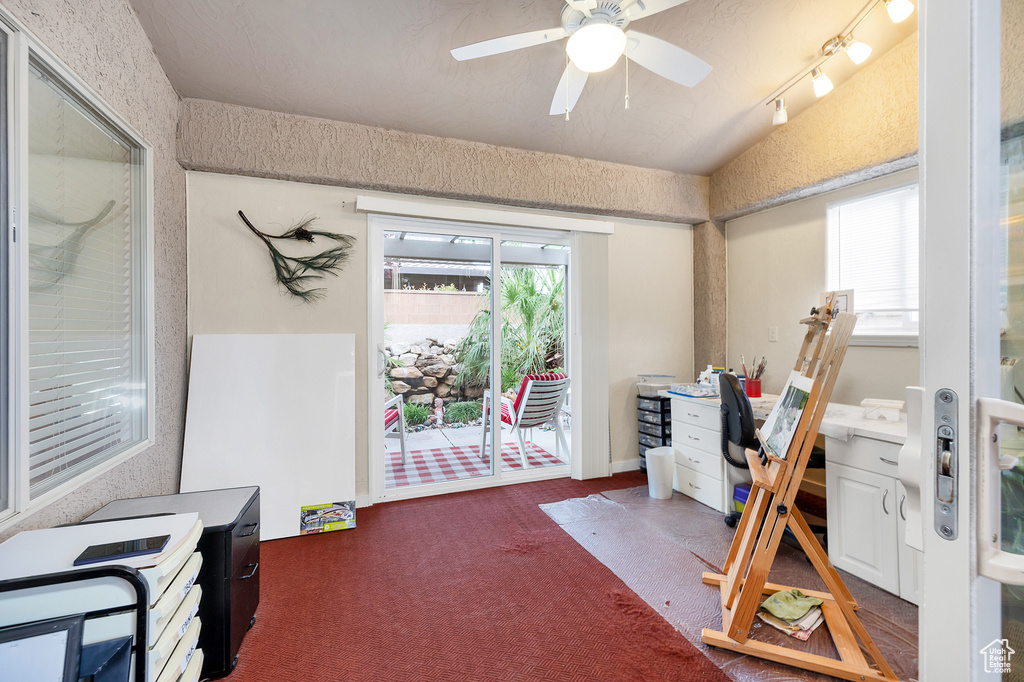 Misc room with an office area, dark carpet, and a ceiling fan