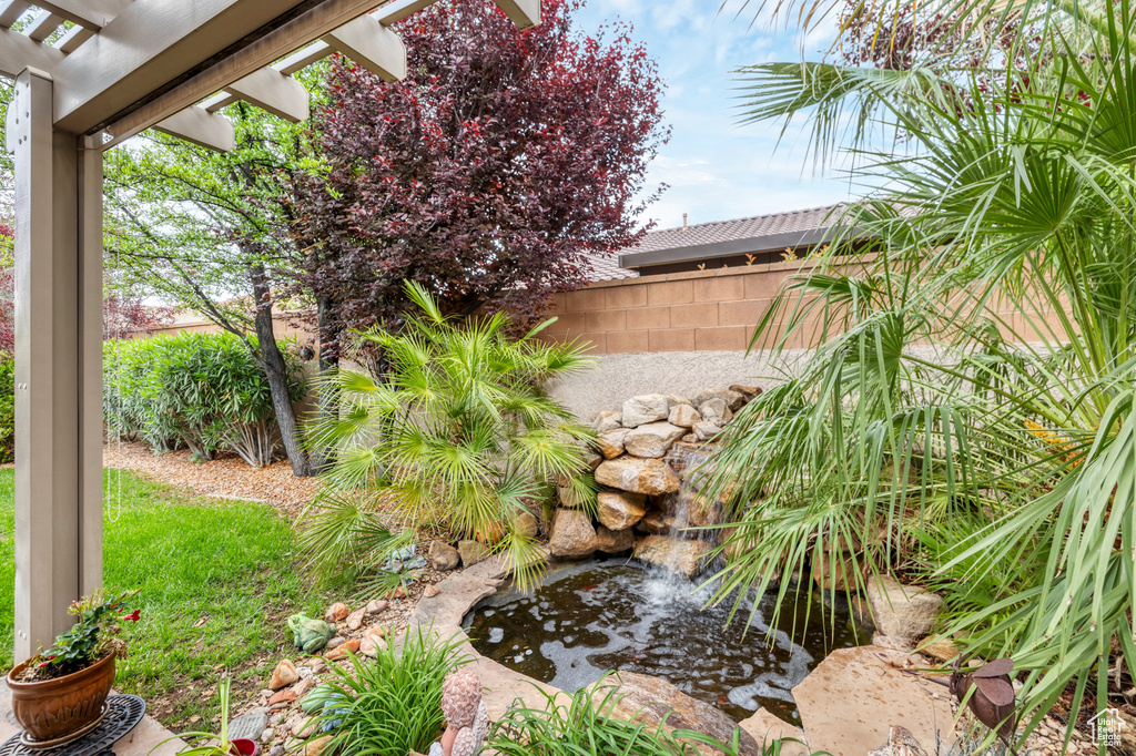 View of yard featuring a garden pond and fence