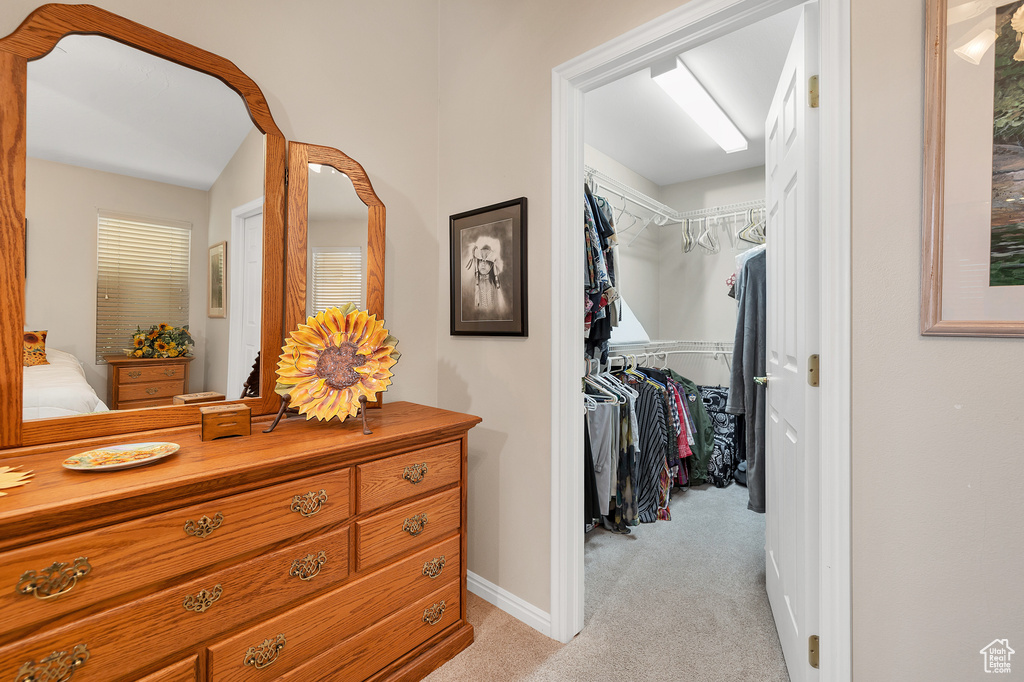 Corridor featuring light colored carpet and baseboards