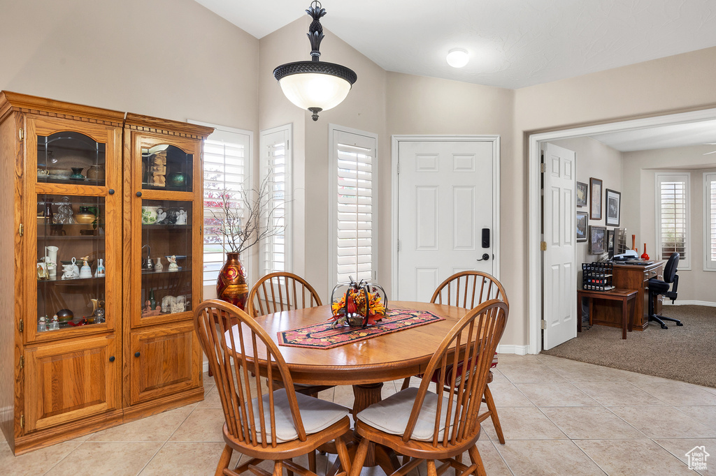 Dining space with light tile patterned floors, an office area, light carpet, and baseboards